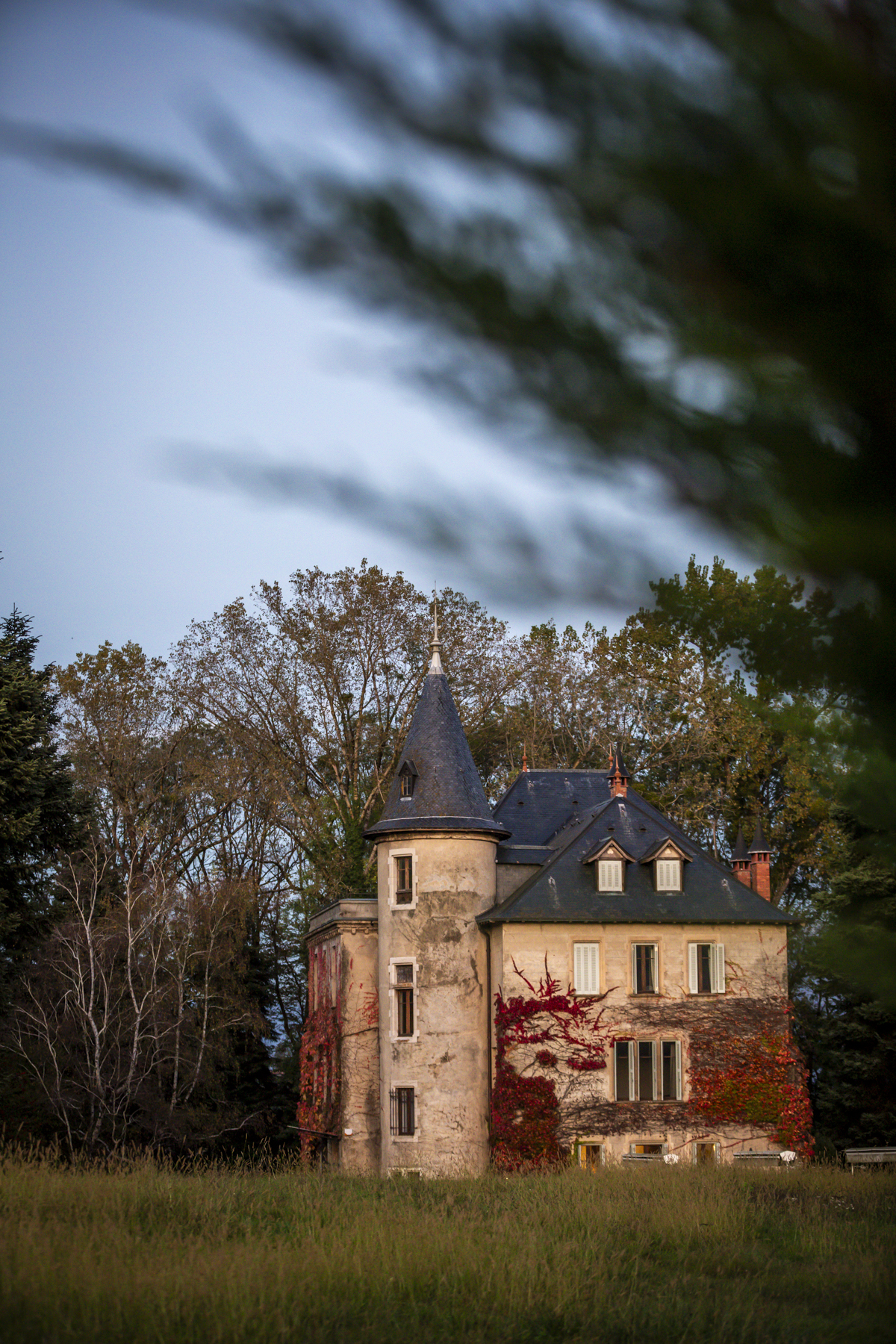 Façade du château en pierre avec sa tour ronde